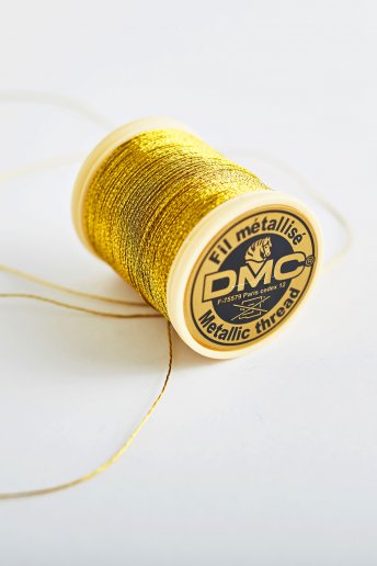 Bobina de hilo metalizado para bordar en color oro oscuro 284a